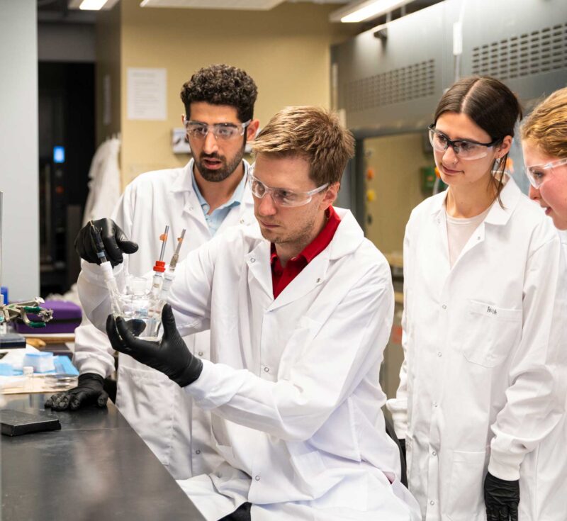 Prof Drew Higgins and students in lab