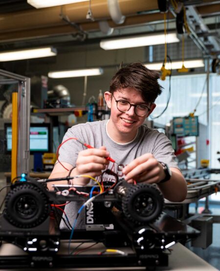 Student working on machine. Hands-on experience.