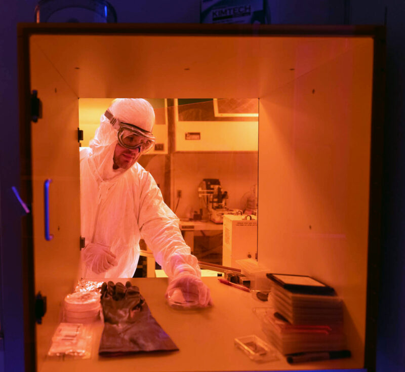 A student picking up petri dish in CEDT clean room