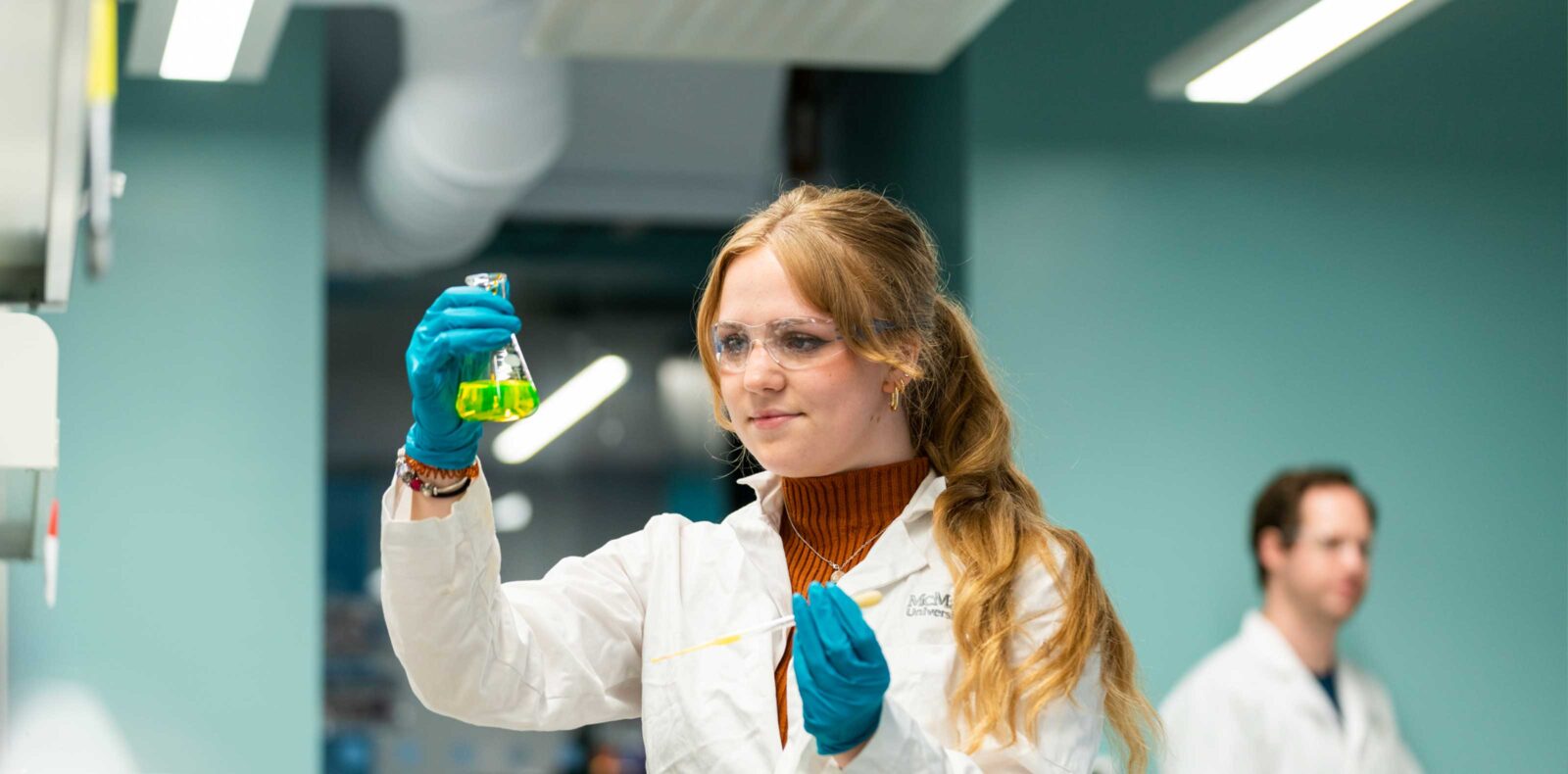 Female student examining sample in Chem Eng Lab