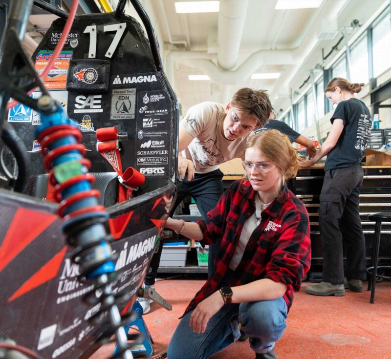 Students inspecting Baja vehicle