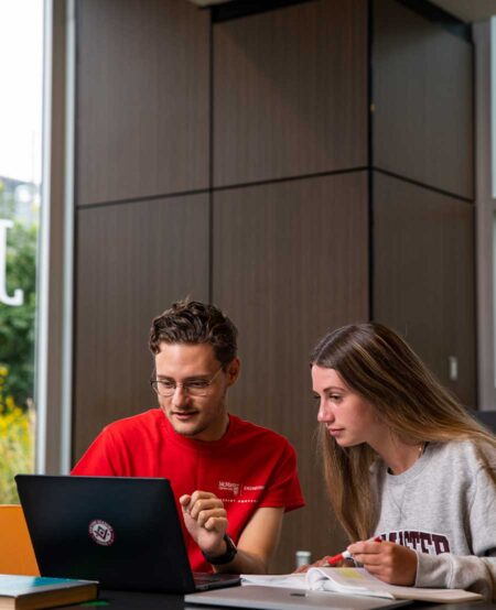 Students looking at laptop in the JHE Lobby