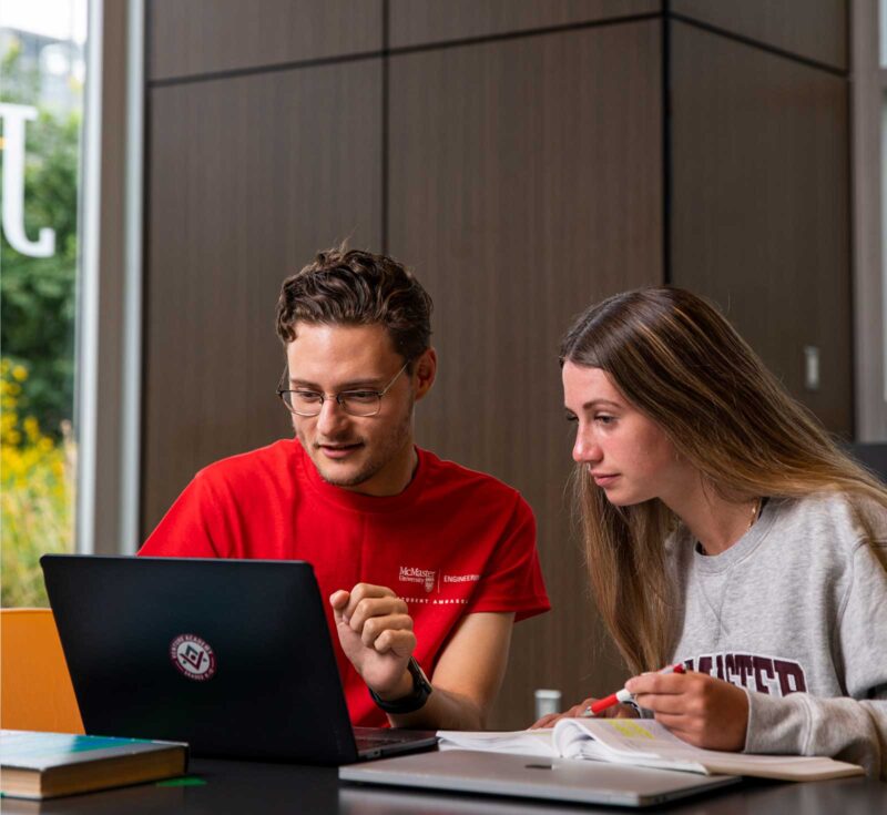 Students looking at laptop in the JHE Lobby