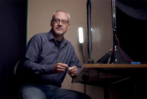 Michael Justason sits beside a lightboard on a desk
