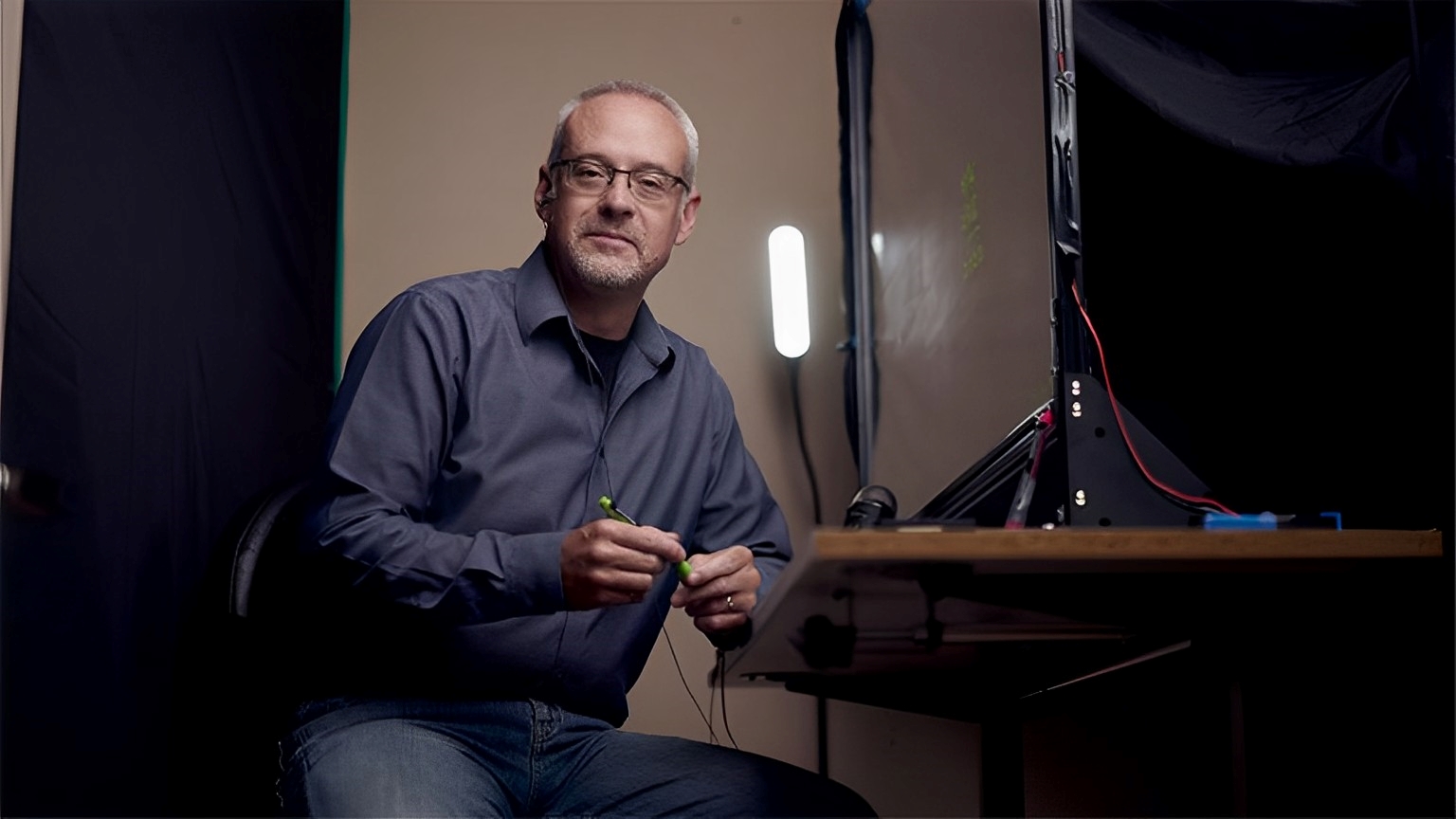 Michael Justason sits beside a lightboard on a desk