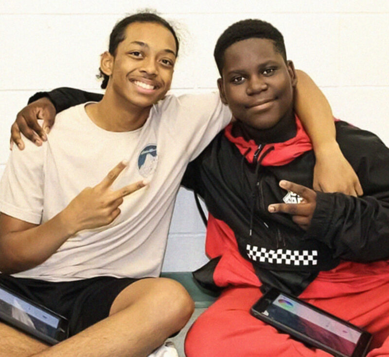 Two boys give peace signs to the camera.