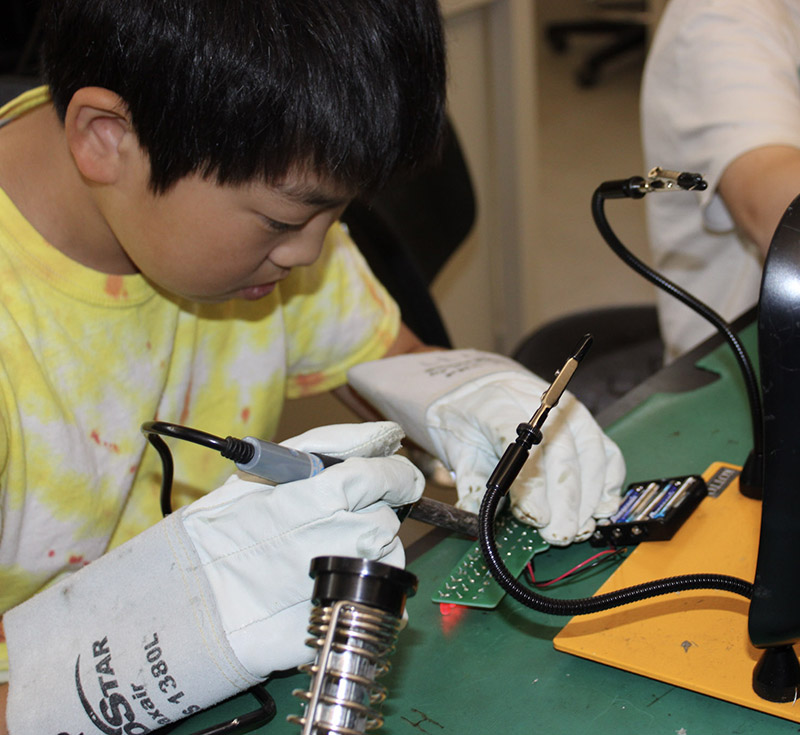 Young person working on a circuit board