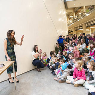 Emily Calandrelli doing an experiment in front of McMaster alumni and staff and their kids