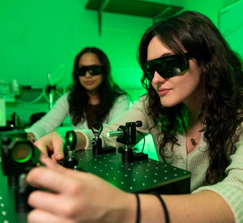 Students in photonics lab with protective dark glasses on