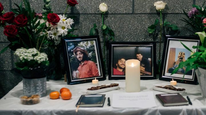 a memorial table with picture frames and lit candles.