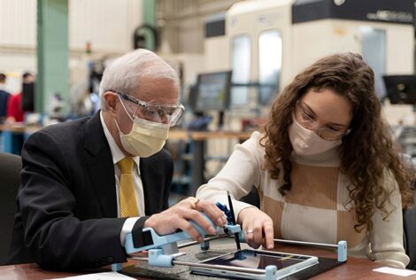 Minister Vic Fedeli tests out Guided Hands, an invention by McMaster engineering student Lianna Genovese.