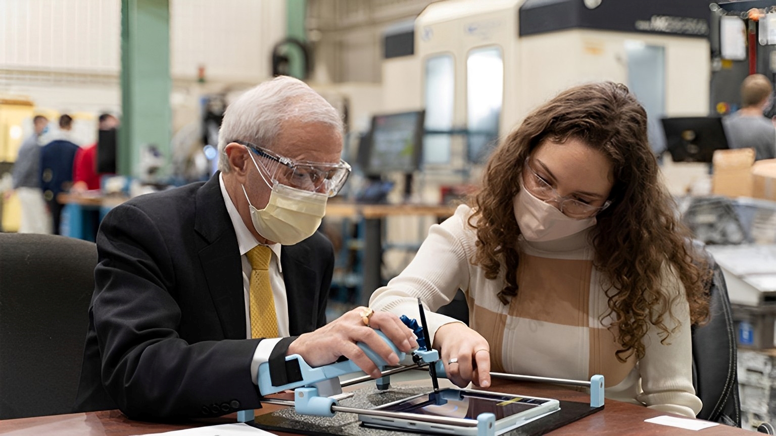 Minister Vic Fedeli tests out Guided Hands, an invention by McMaster engineering student Lianna Genovese.