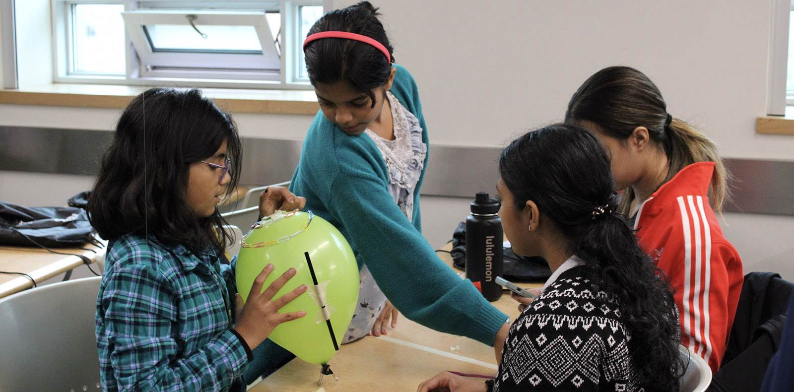 Youth working on a STEM activity with a balloon