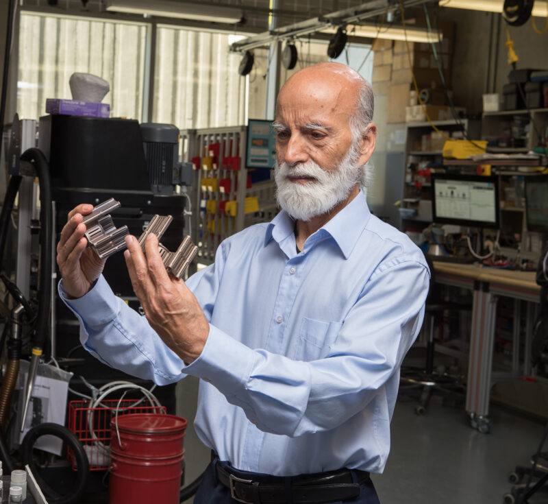 Researcher Ishwar Singh looking at metal samples created by a 3D printer.