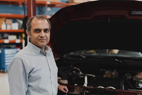 Babak Nahid-Mobarakeh stands by a vehicle's engine.