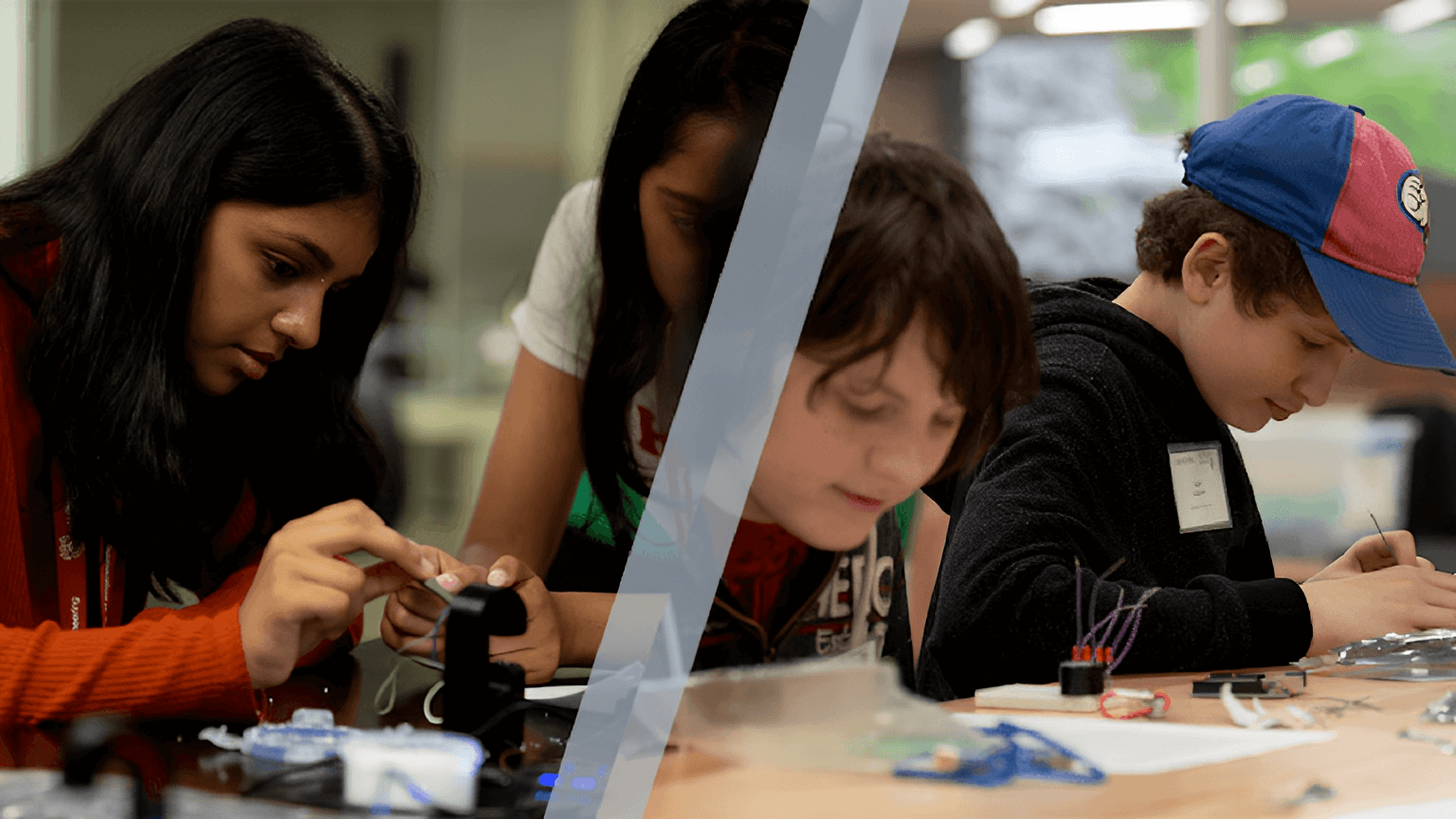 school aged children sitting at a table working on engineering projects.