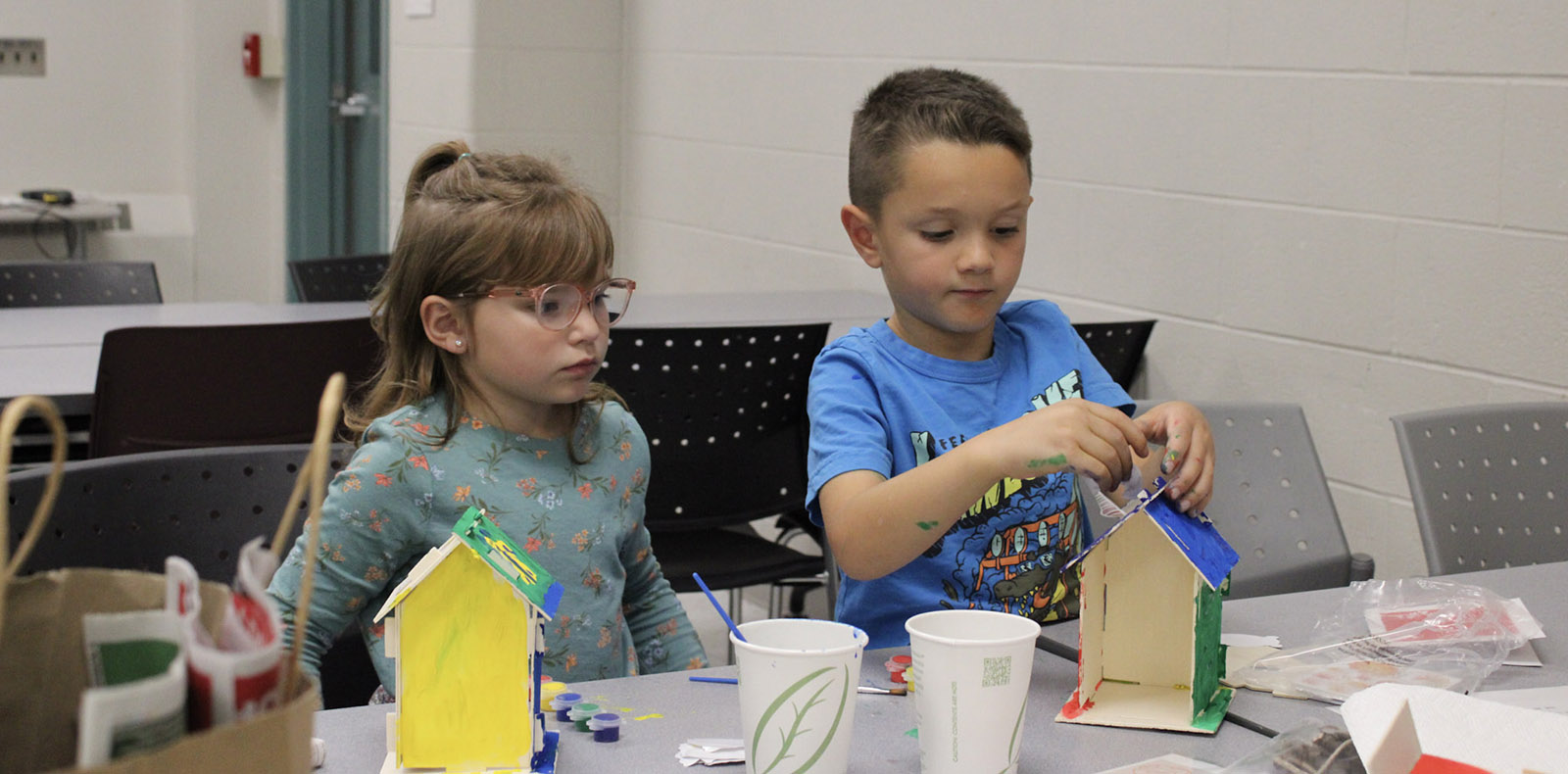 Two kids concentrating on a STEM activity at a table
