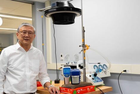 Chan Ching standing beside an air purification system.