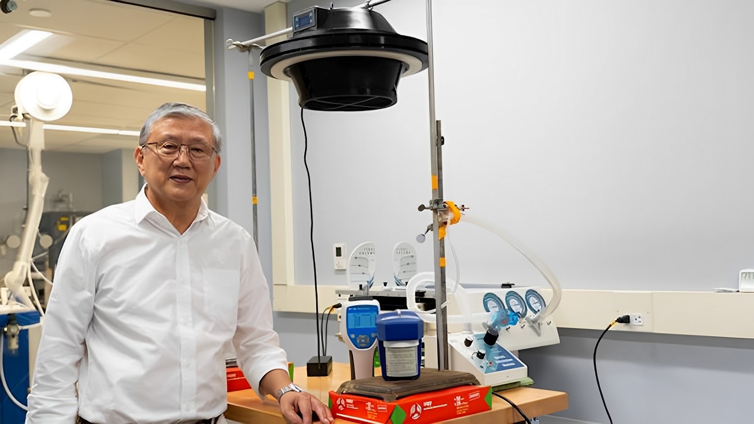 Chan Ching standing beside an air purification system.