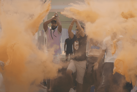 group of students walking through orange powder.