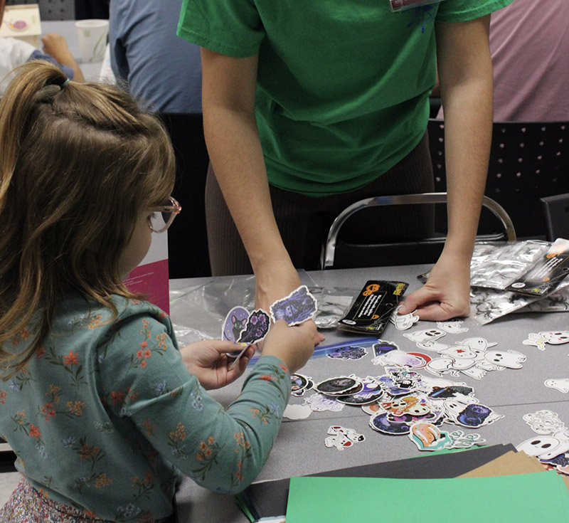 Student picking out stickers from a table