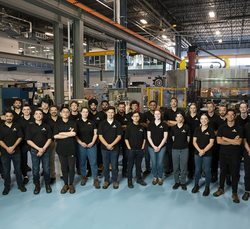 Students in black t-shirts standing together in a group at MMRI