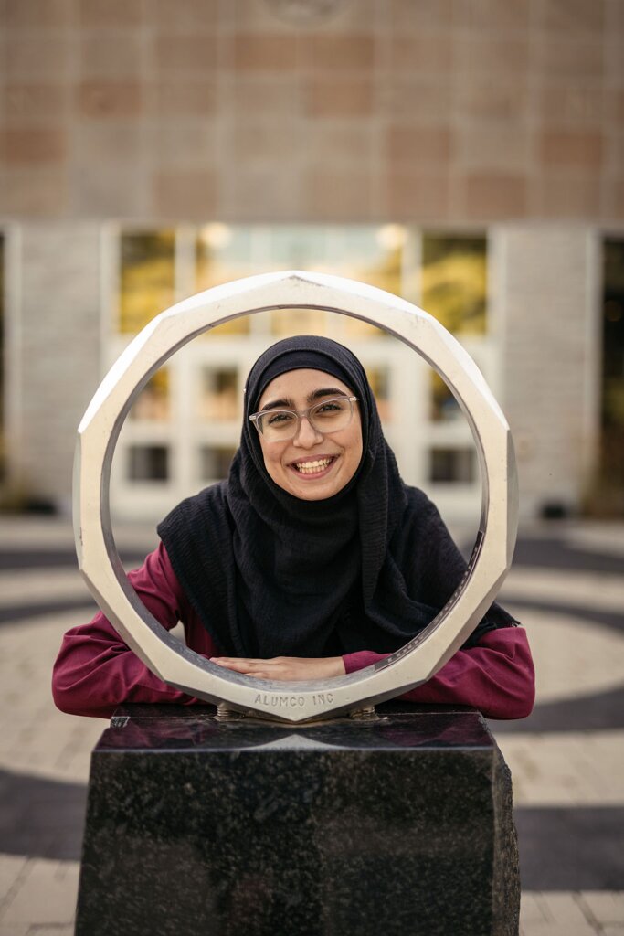 Javayria Mudassar smiles in the centre of the iron ring outside the John Hodgins Engineering Building.