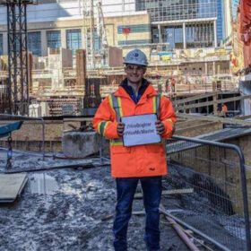 Michael Sucharda holds a sign at a construction site.
