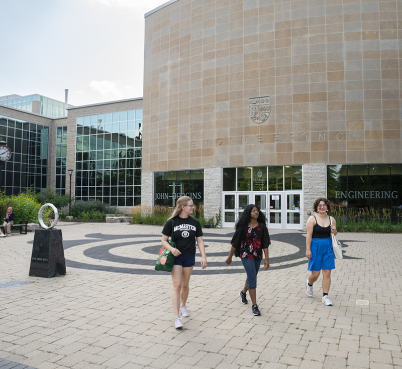 Three women walking together outside of JHE on campus