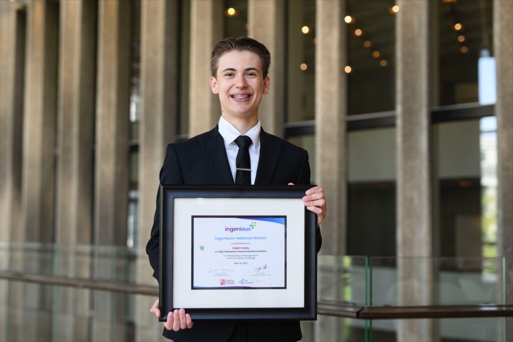 Elijah Cosby holding a framed certificate