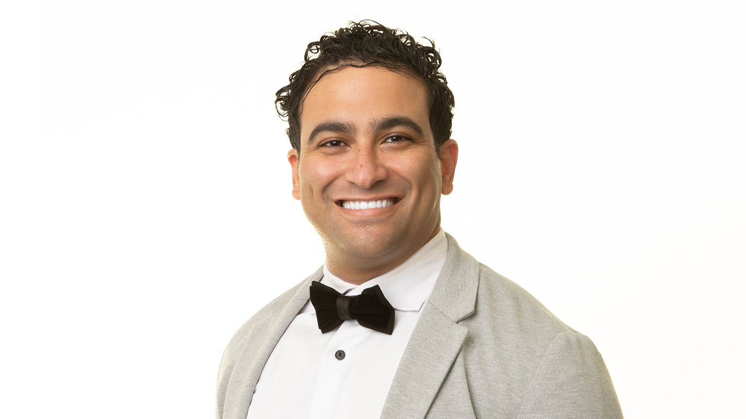 Ryan Ahmed smiling and wearing a bow tie