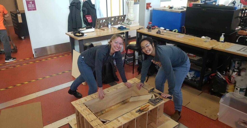 Kristin Seymour and Alisa Neang in the Hatch build space working on the concrete toboggan superstructure