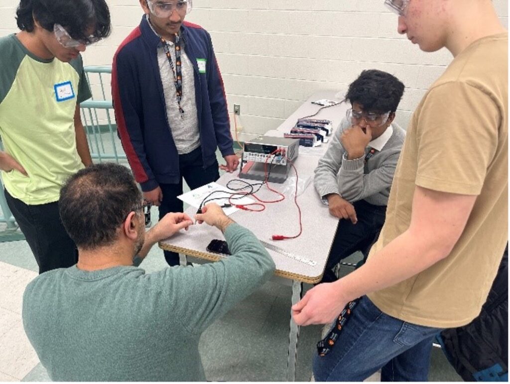 a group of students working with a resistance testing machine. 