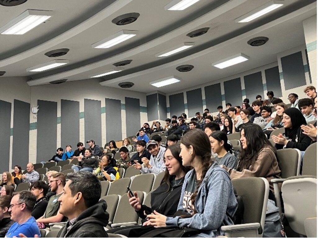 an auditorium full of students sitting in their seats.