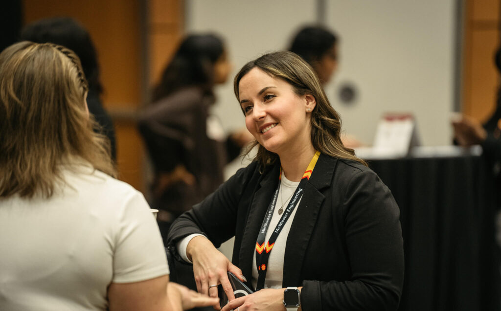 A person smiles while networking at a women in engineering industry event.