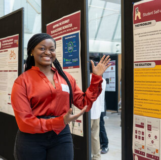 Smiling MacChangers participant motioning to a poster