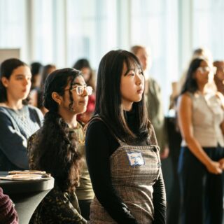 A crowd of students listening to a presentation.