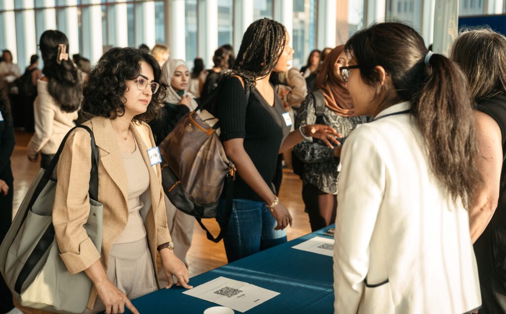 Student networking with an employer at a table.
