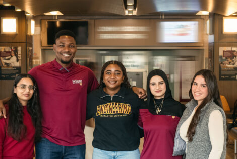 Five students standing together on campus