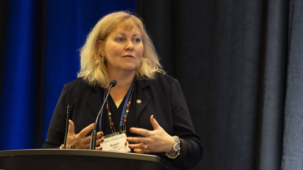 Susan Tighe speaking at a podium