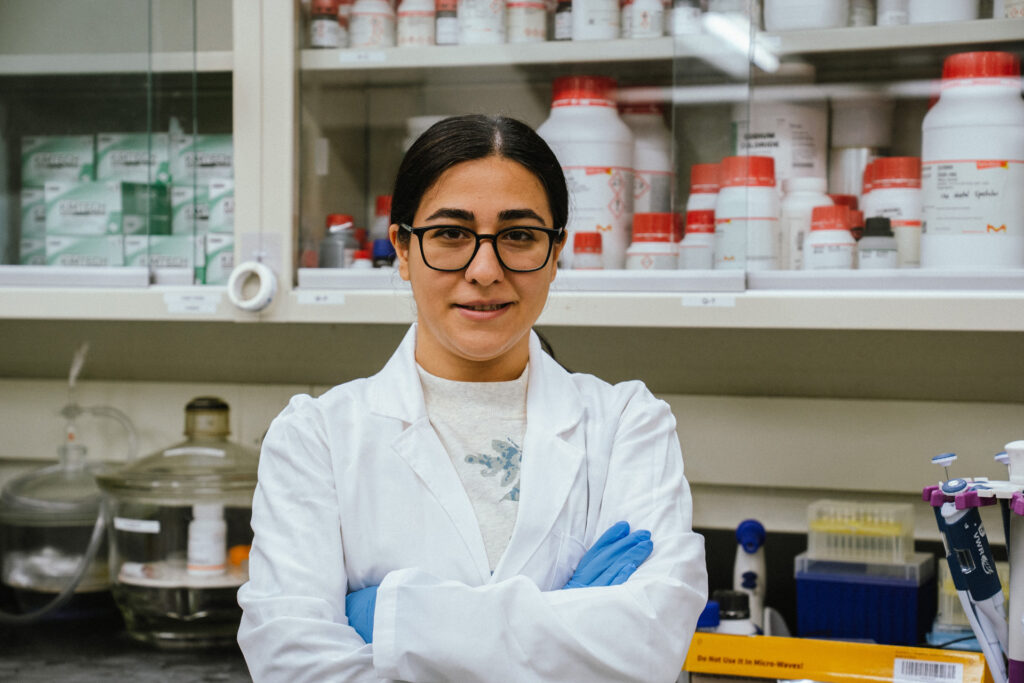 Zahra smiling with her arms crossed in the lab