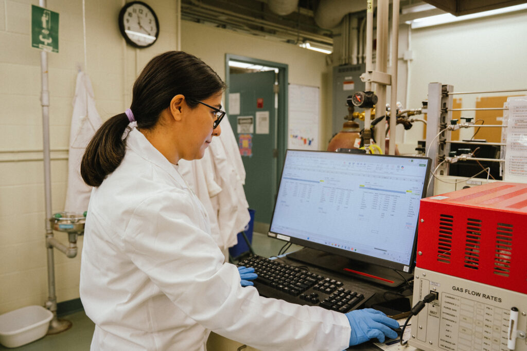 Zahra looking at data on a computer in the lab