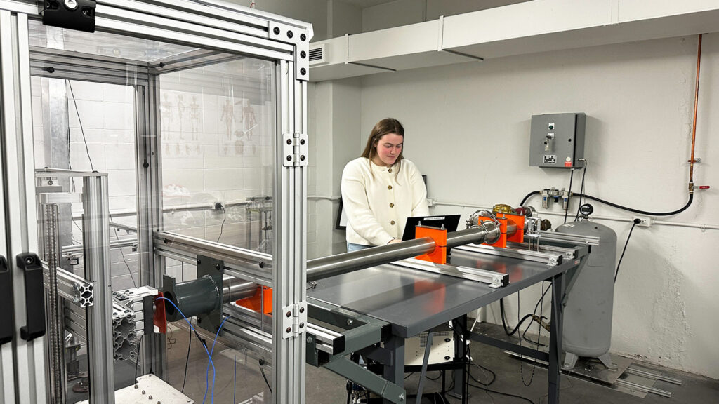 Morgan Pluim working on a pneumatic air compressor set up in the McMaster Injury Biomechanics Lab.