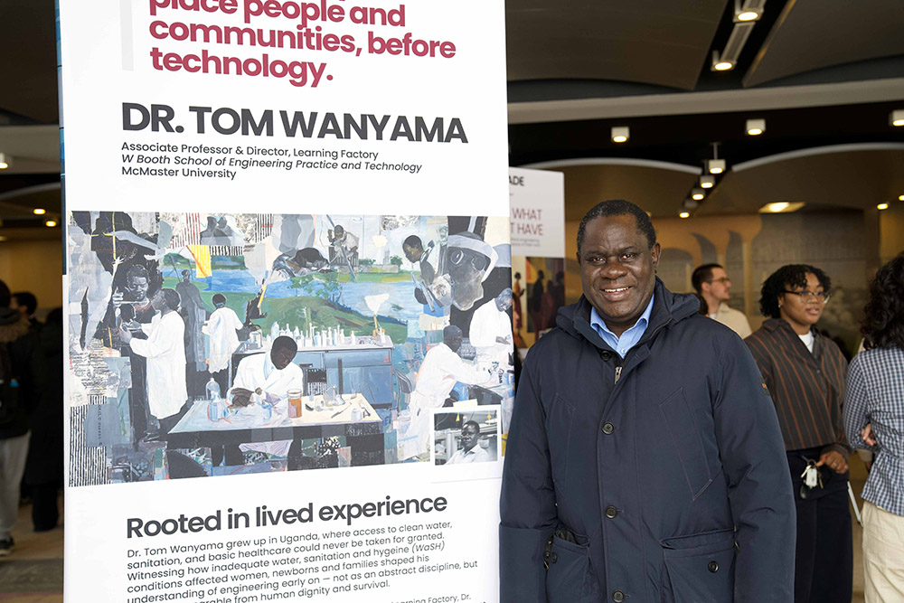 Tom Wanyama standing next to artwork with his likeness
