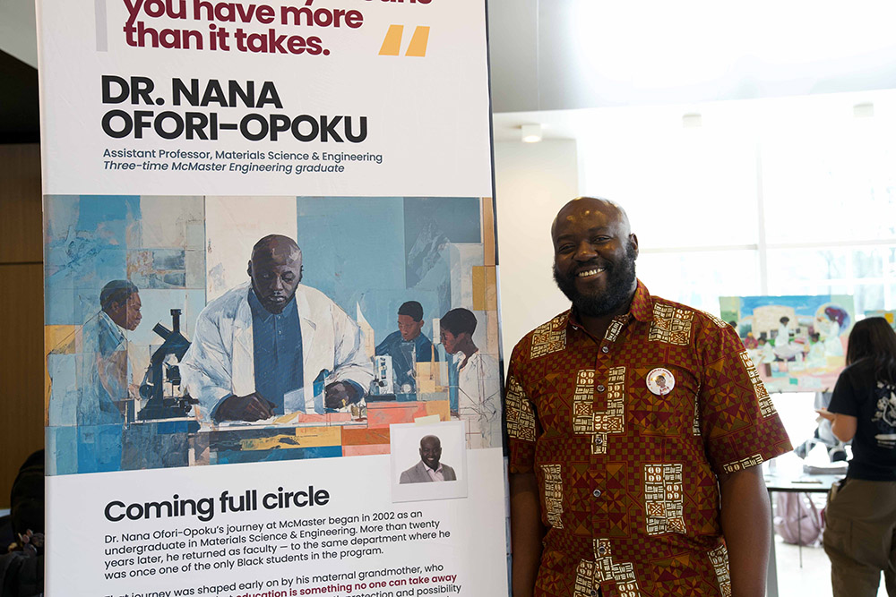 Dr. Nana Ofori-Opoku standing next to a display with his likeness