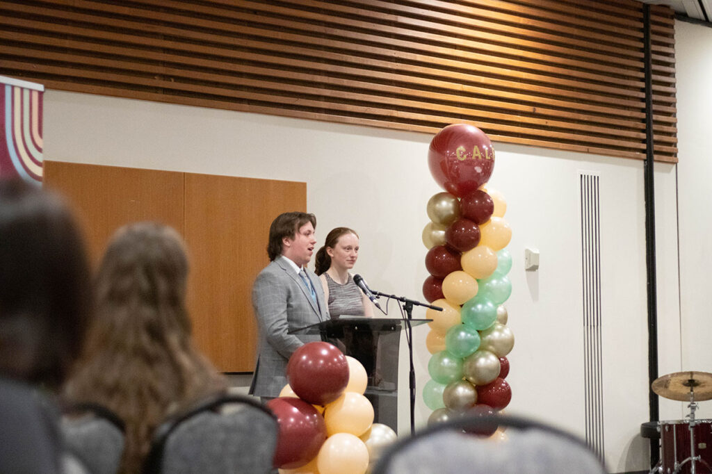 CALE co-leads speaking at a podium