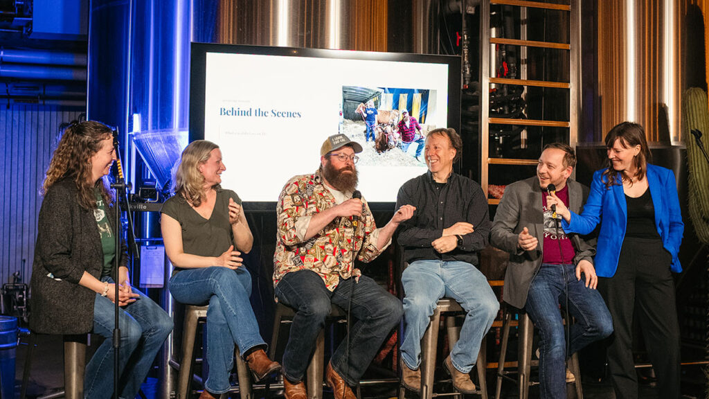 A panel of people with a microphone at the event