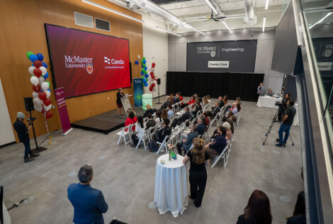 Overhead view of a large room with people seated and someone at a podium talking
