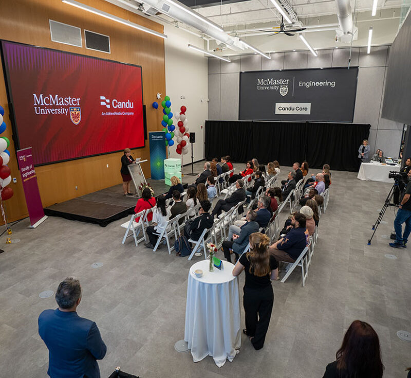 Overhead view of a large room with people seated and someone at a podium talking