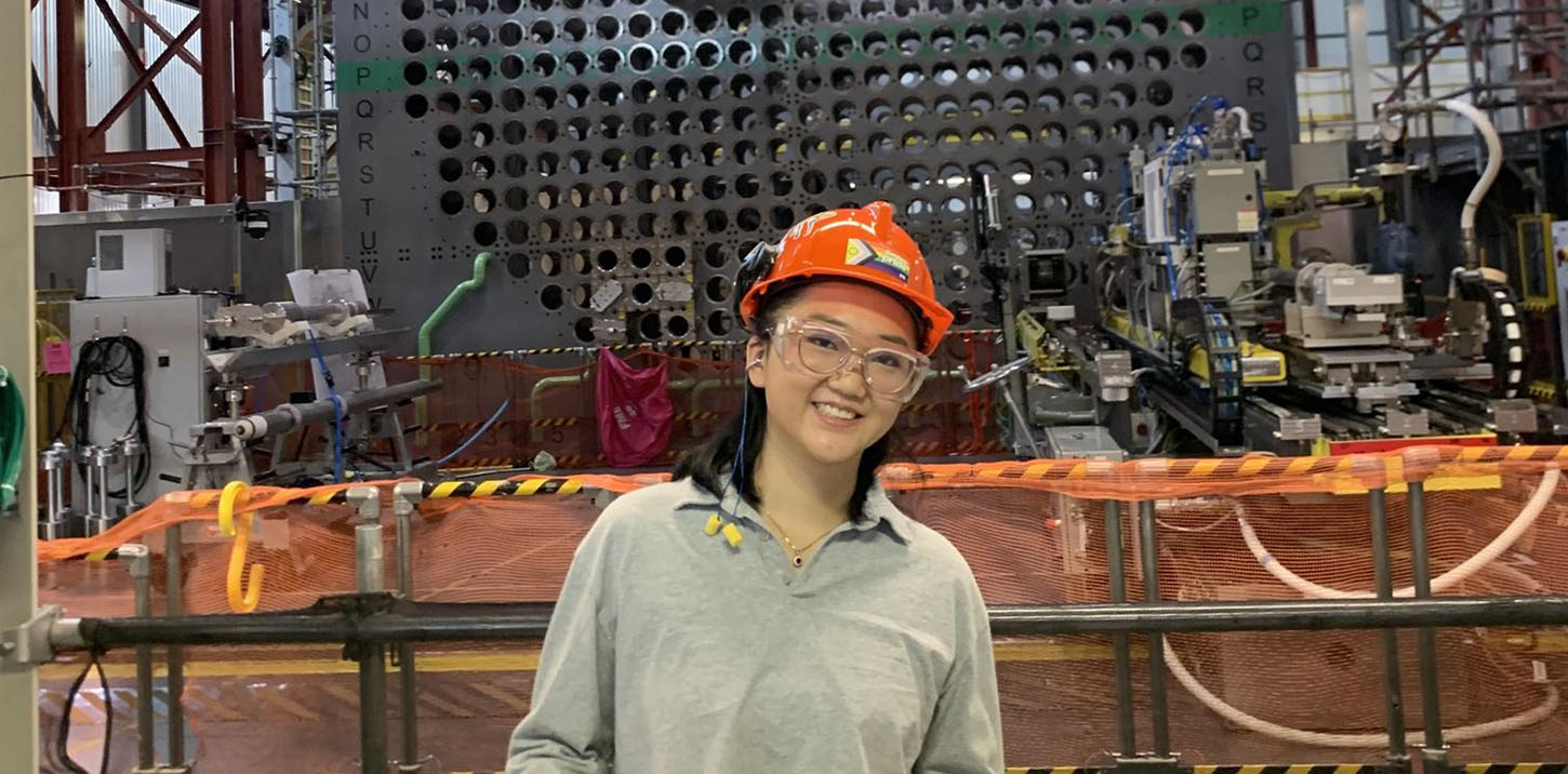 Spring Fu standing in front of a nuclear reactor